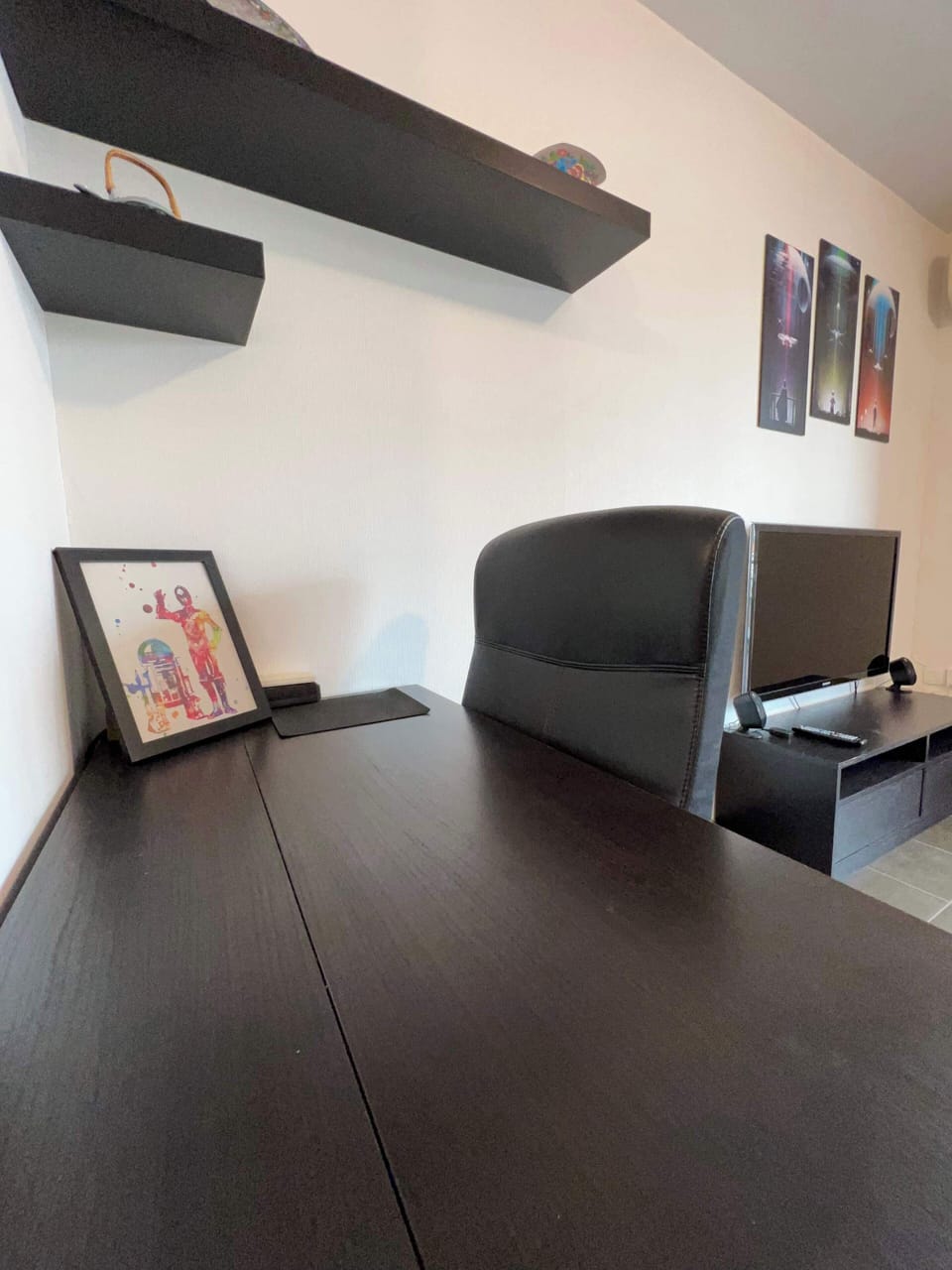 Espace salon avec fauteuil, cadres décoratifs et ambiance moderne