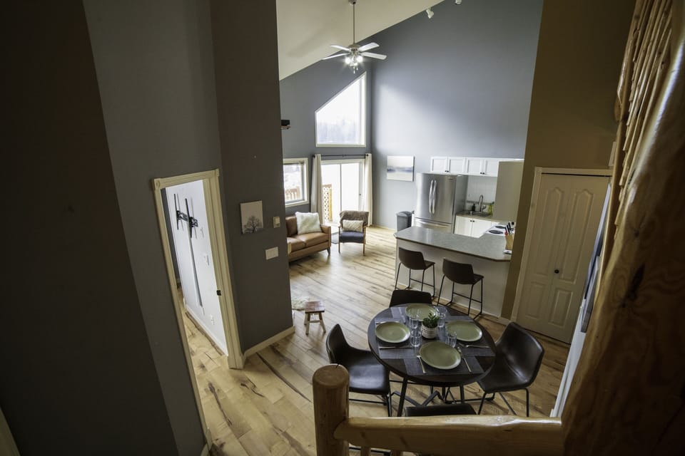 Living room. Bright, open space with high ceilings and mountain cabin vibe.