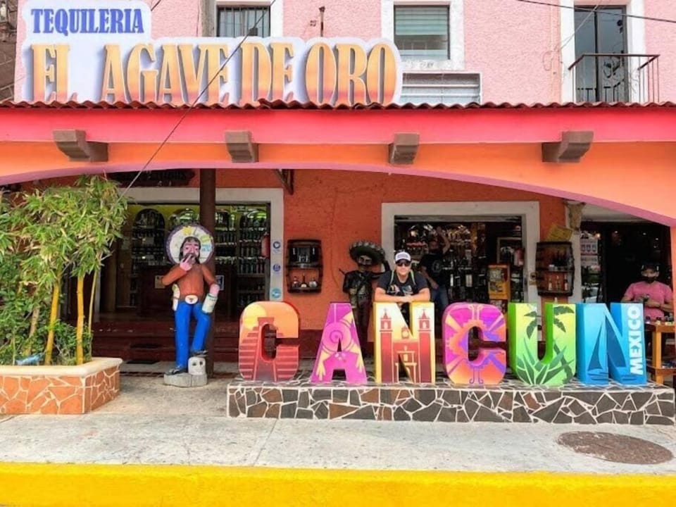 Nearby: downtown Cancun market and Cancun sign.
