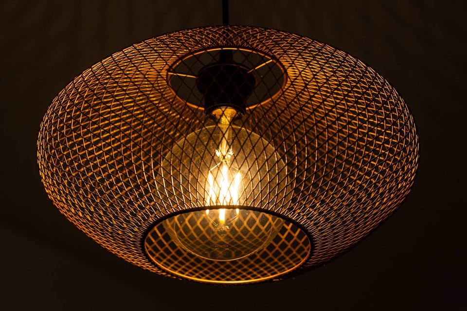A modern, golden industrial-style ceiling lamp adds character to the interior.