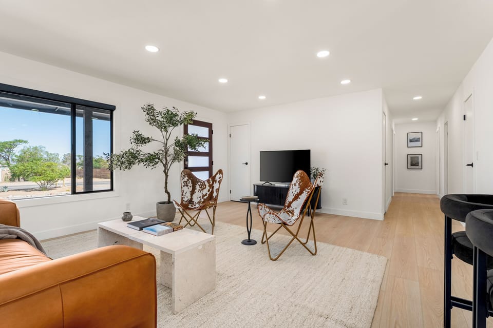 Kick back in the stylish living room with a TV, comfortable seating, and easy access to the rest of the home.