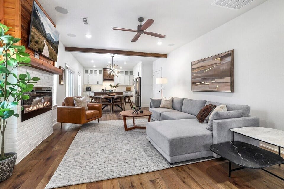 This space features a large sectional, chair, 60-inch Smart TV, and an electric fireplace.