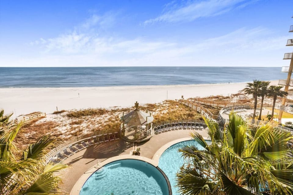 View over balcony railing down to central pool, and private entrances to beach