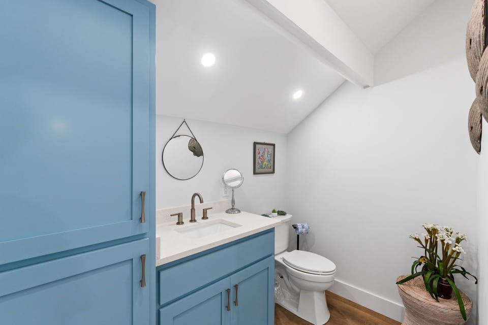 Freshen up in your cheerful bathroom with coastal-inspired touches, crisp white countertops, and thoughtful details like fresh flowers to make you feel right at home.