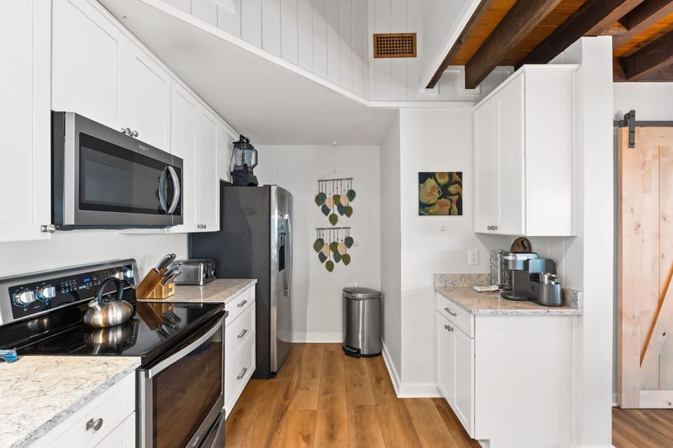 Your fully equipped kitchen features sleek stainless-steel appliances, ample counter space, and warm wood floors—perfect for whipping up a delicious meal after a day of adventure.