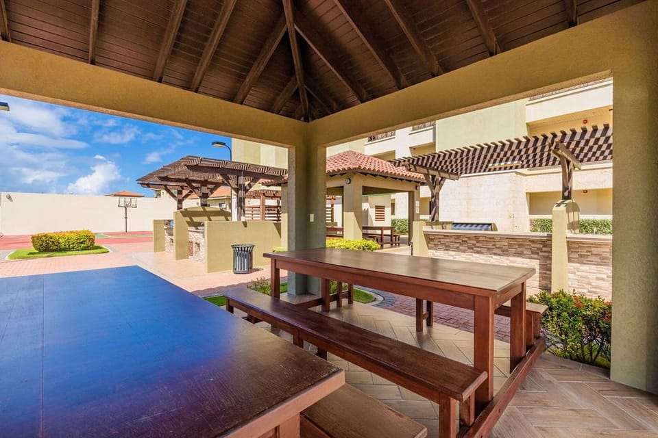 An outdoor BBQ area with dining table and seating.
