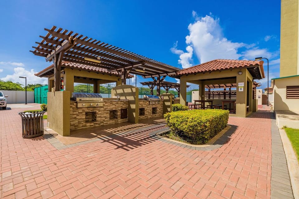 An outdoor BBQ area with dining table and seating.