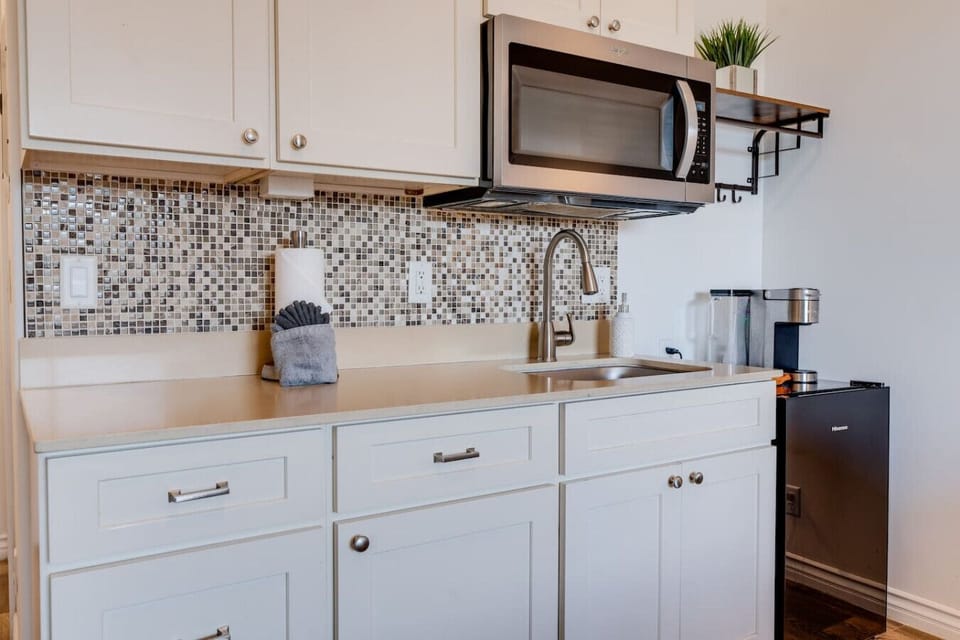 Kitchenette equipped with essential tools for preparing small meals. There is no stove or oven, but it includes a portable hot plate, skillet, and other basic cookware
