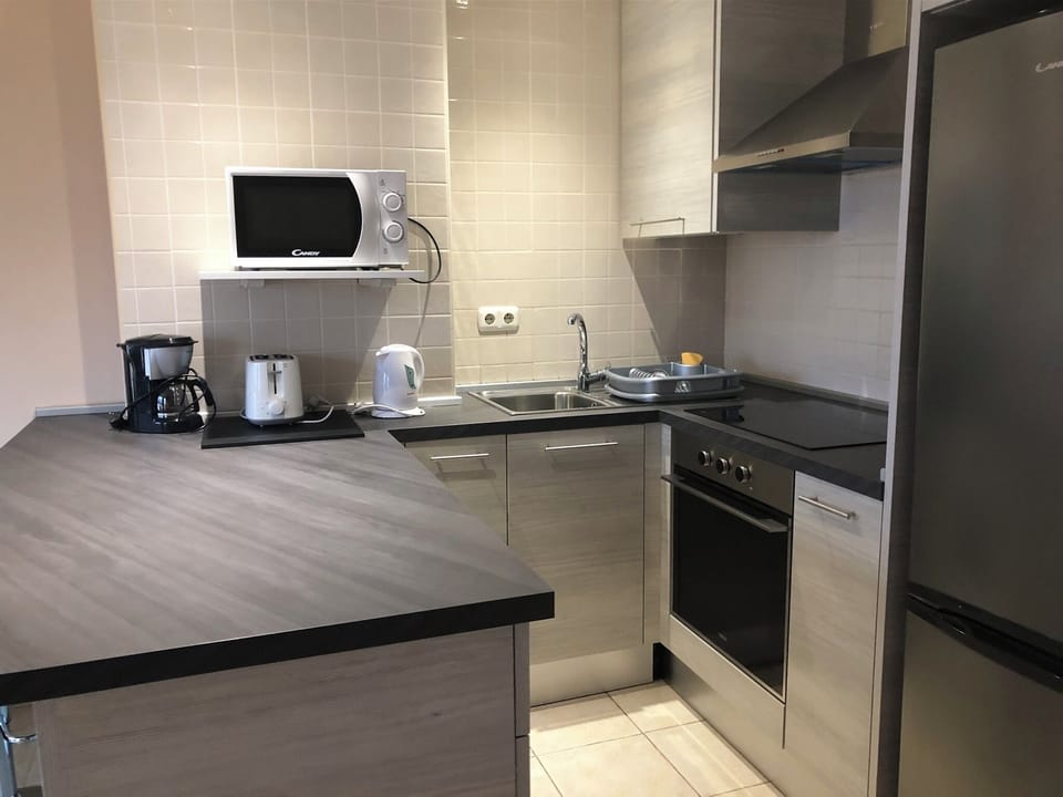 Kitchen with oven, hob and tall fridge freezer.