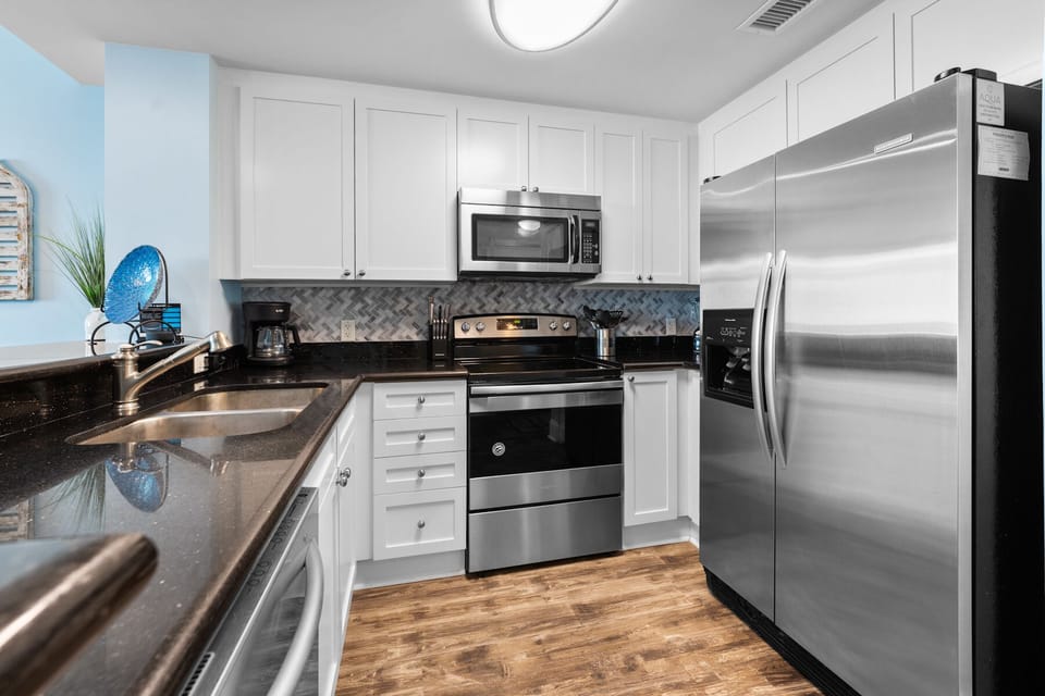 Your fully equipped kitchen features granite countertops, stainless steel appliances, and bright white cabinetry perfect for preparing memorable meals.