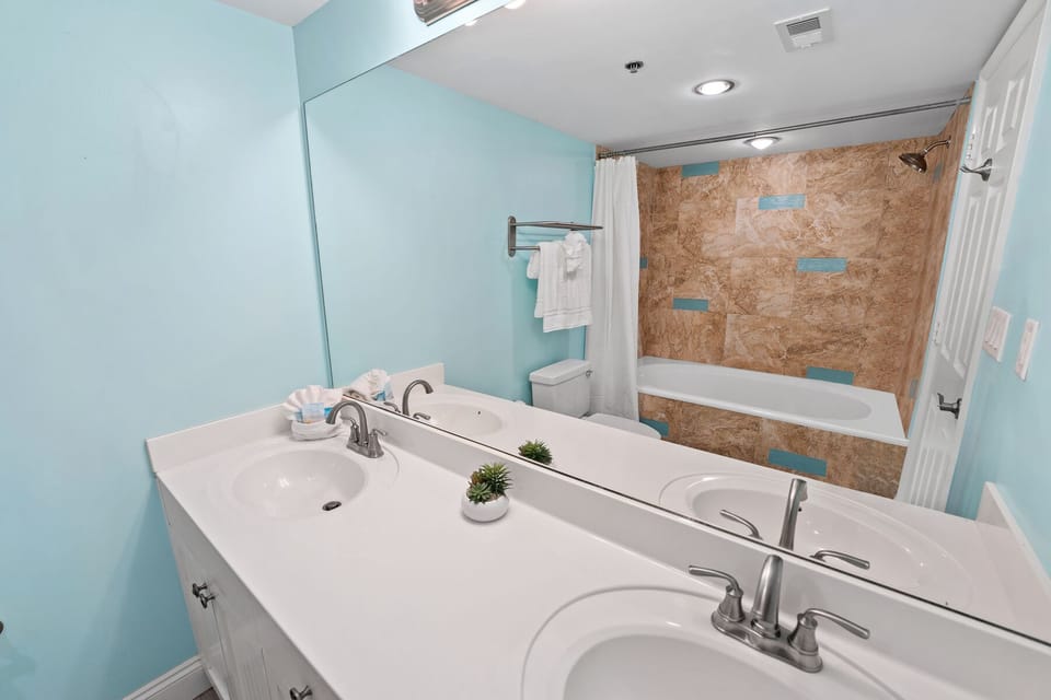 Refresh in your private spa-like bathroom featuring dual sinks, soaking tub, and soothing coastal colors.