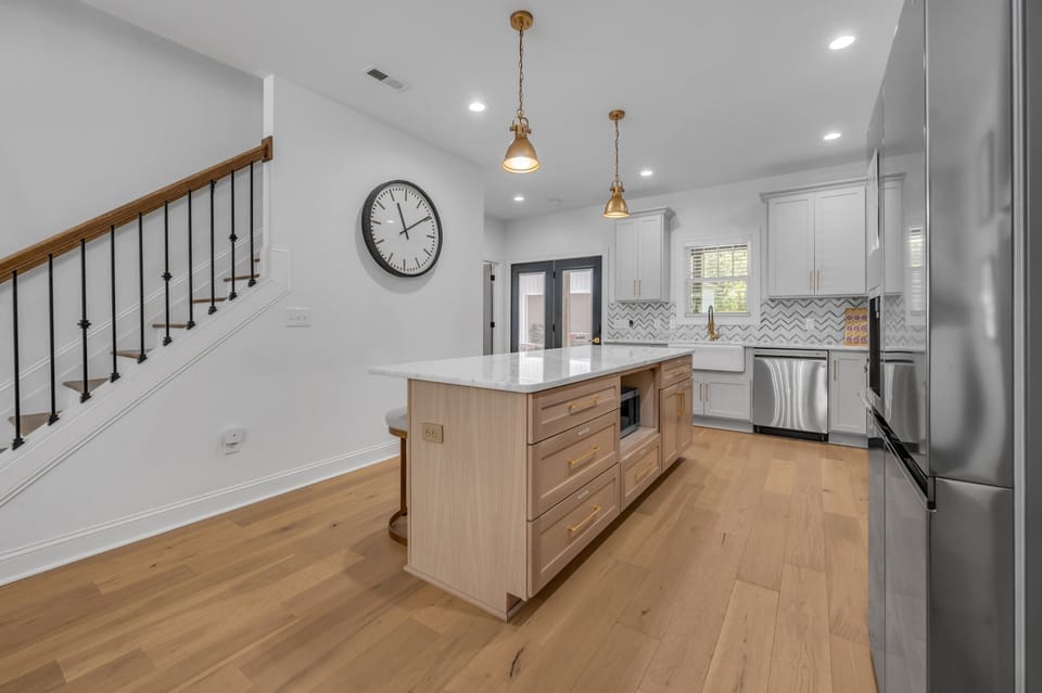 Gather around the stylish kitchen island featuring a glamorous countertop and comfortable seating, perfect for casual dining, morning coffee, or socializing while cooking.