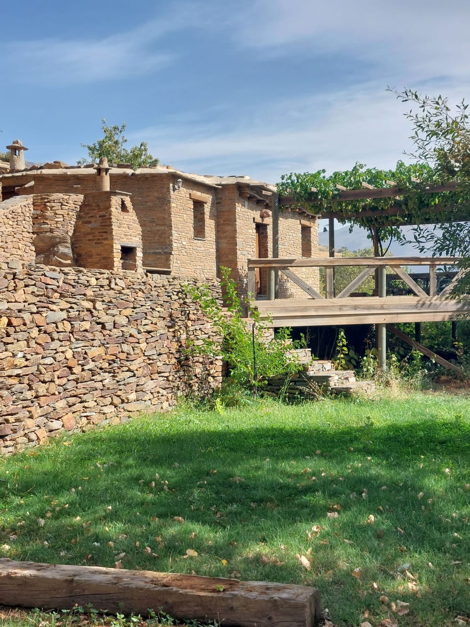 View of outside of Walnut cortijo with wooden terrace, Cortijos Rey Fini.