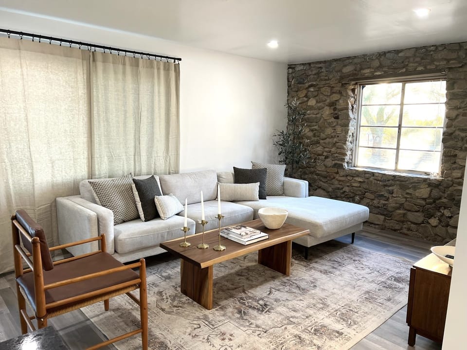 Updated modern living room with the original 1920’s rock wall. 