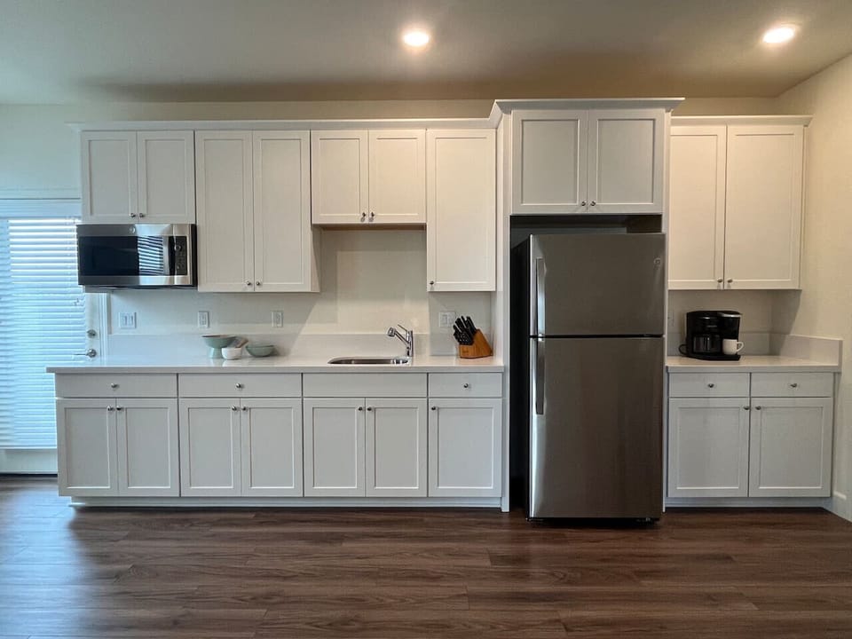 Kitchenette with large sink, refrigerator with ice maker, 3-in-1 combo microwave, convection oven, and air fryer. Water and desert views from the door leading to the private patio.