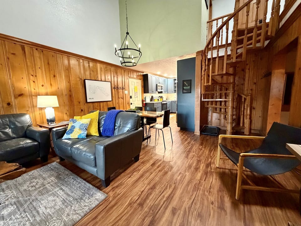 Modern cabin charm meets mid-century comfort — vaulted ceilings, warm wood accents, and a signature spiral staircase leading to the loft.