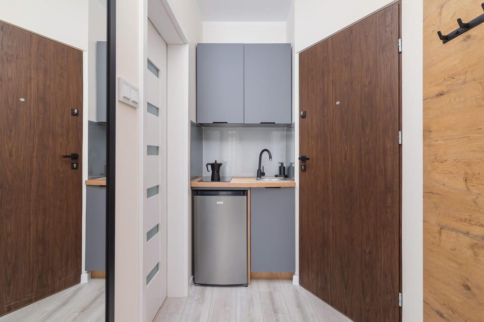 A hidden kitchenette with wooden cabinets, a compact yet functional space for cooking.
