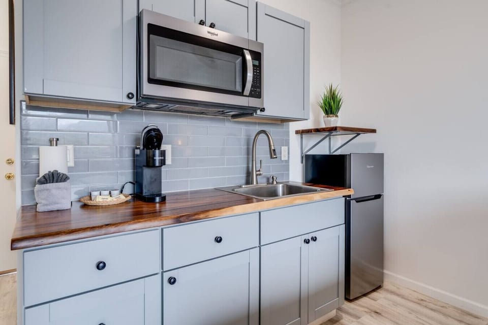 Kitchenette equipped with essential tools for preparing small meals. There is no stove or oven, but it includes a portable hot plate, skillet, and other basic cookware