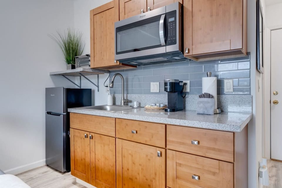 Kitchenette equipped with essential tools for preparing small meals. There is no stove or oven, but it includes a portable hot plate, skillet, and other basic cookware