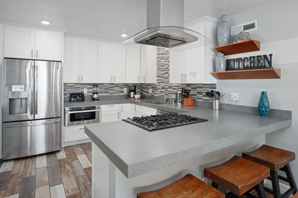 Kitchen with a bar and stools, ideal for casual dining.