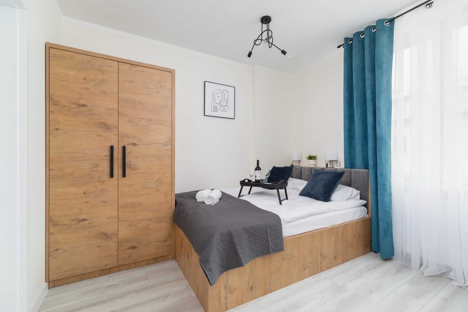 A compact bedroom with a comfortable bed and wooden cabinetry for storage.

