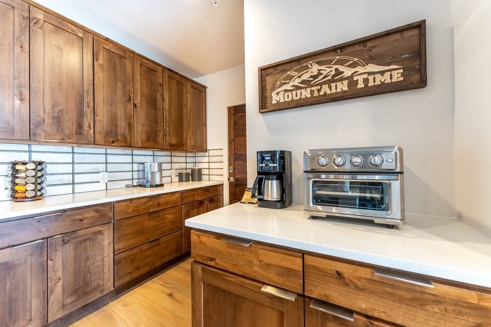 Your fully equipped kitchen features rich wood cabinetry and modern appliances, perfect for preparing mountain meals together.