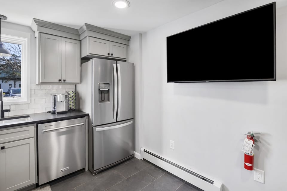 TV on kitchen wall allows bar seating for the big game