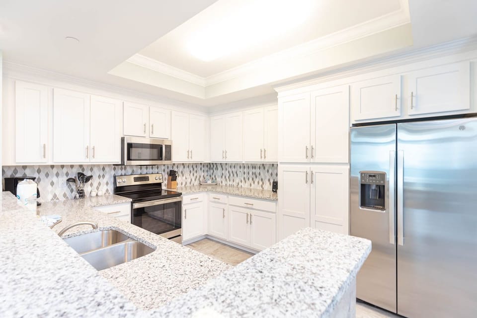 Prepare meals in this stylish kitchen with stainless appliances and admire the patterned backsplash