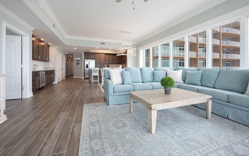 Settle into the large sectional and feel warm light fill the room through the wall of windows