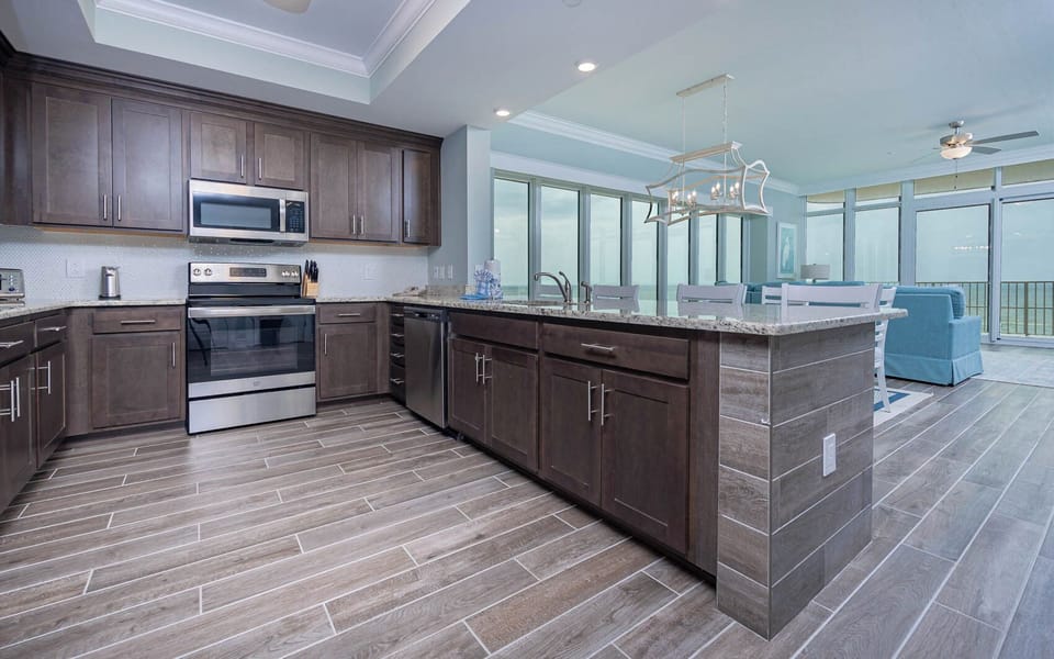 Prepare meals in this stylish kitchen with elegant cabinetry, stainless appliances, and panoramic beach views