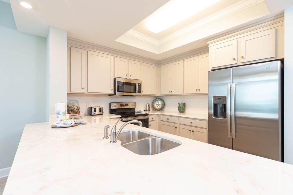 Prepare meals in this stylish kitchen with stainless appliances, spacious counters, and sleek cabinetry