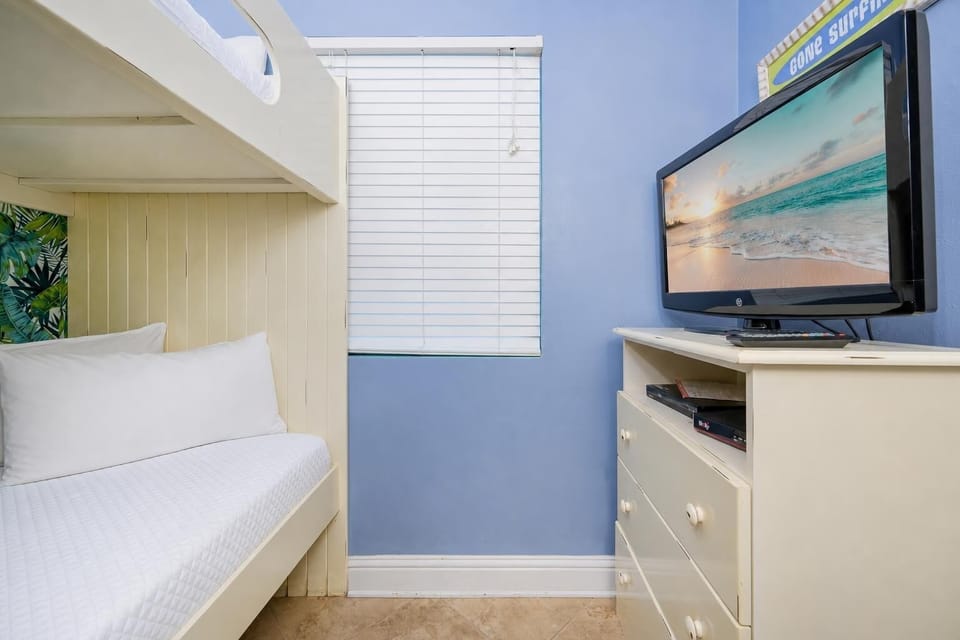 Blue walls surround the bunk room where you relax watching a movie on the TV
