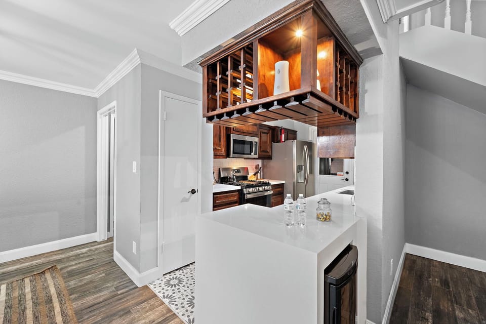 Stylish waterfall countertop plus mini fridge, providing convenience for refreshments.