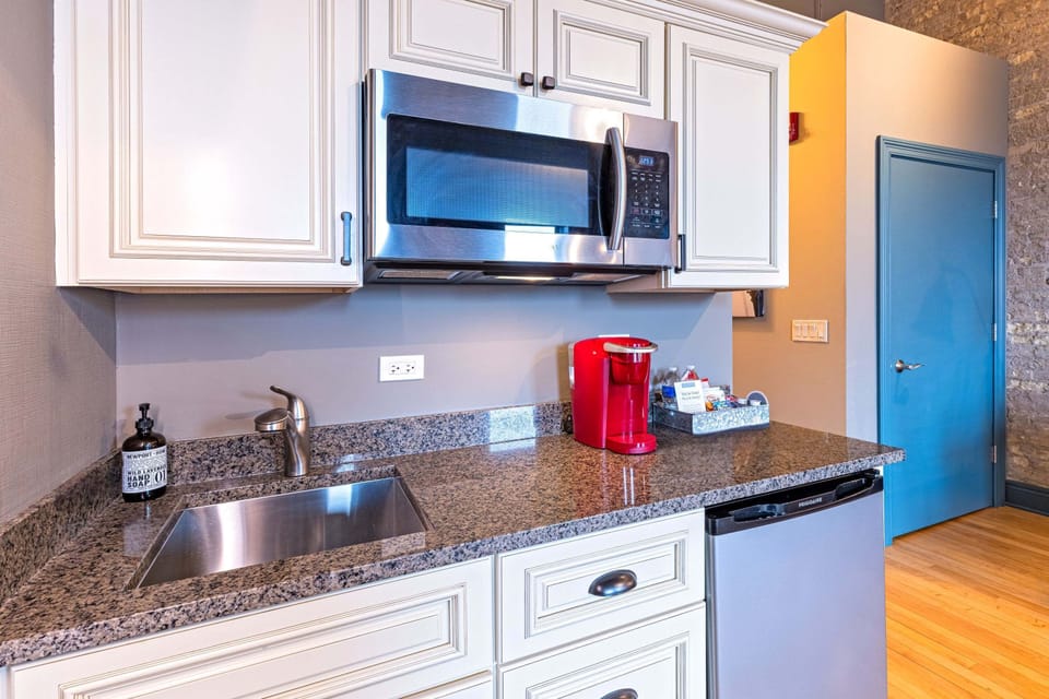 Fully equipped kitchenette with granite countertops, stainless sink, microwave, mini fridge, and Keurig coffee maker - everything you need for a comfortable stay.