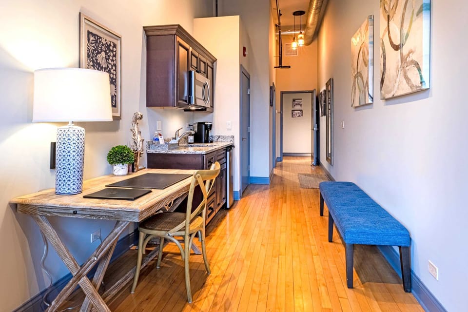 The open layout flows from workspace to kitchenette to hallway - designed to feel spacious without wasting a square foot.