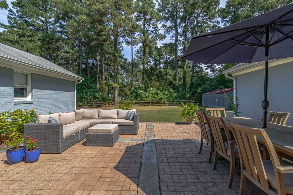 Outdoor courtyard with grill, ample seating, and large fenced-in yard