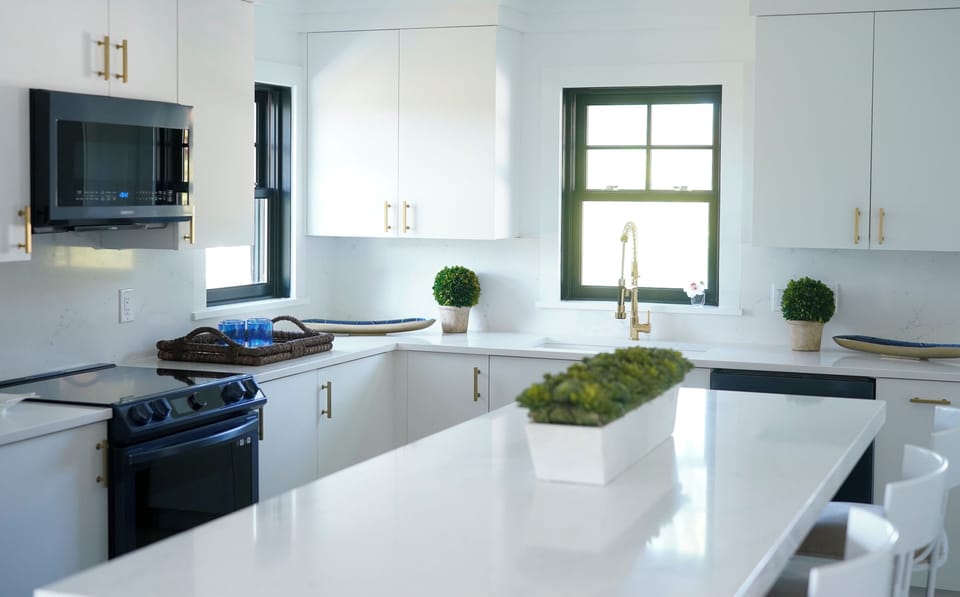 Very large open kitchen design with white quartz island and counter tops.