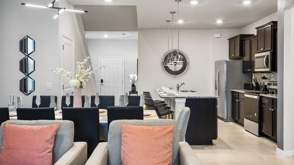 Elegant dining and kitchen area with modern lighting, sleek island, and cozy vibes!
