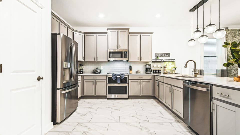 Spacious chef’s kitchen with stainless steel appliances and a stylish coffee bar.