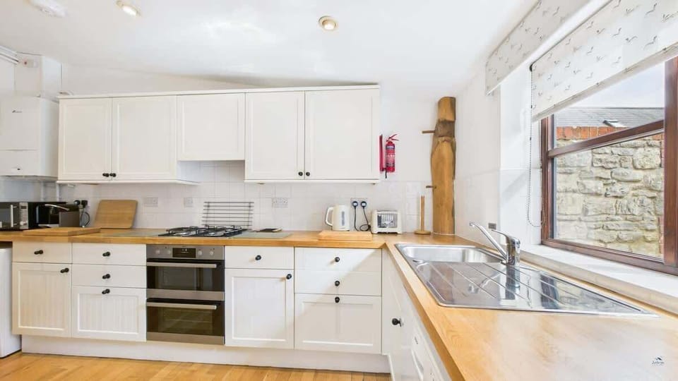 Detail of appliances at The Cote kitchen including oven, microwave, fridge/freezer, washing machine and kettle.
