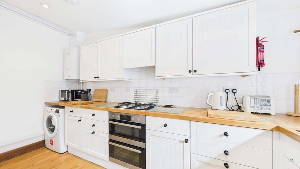 Well-equipped kitchen with washing machine, oven, microwave, kettle, toaster & coffee machine. 