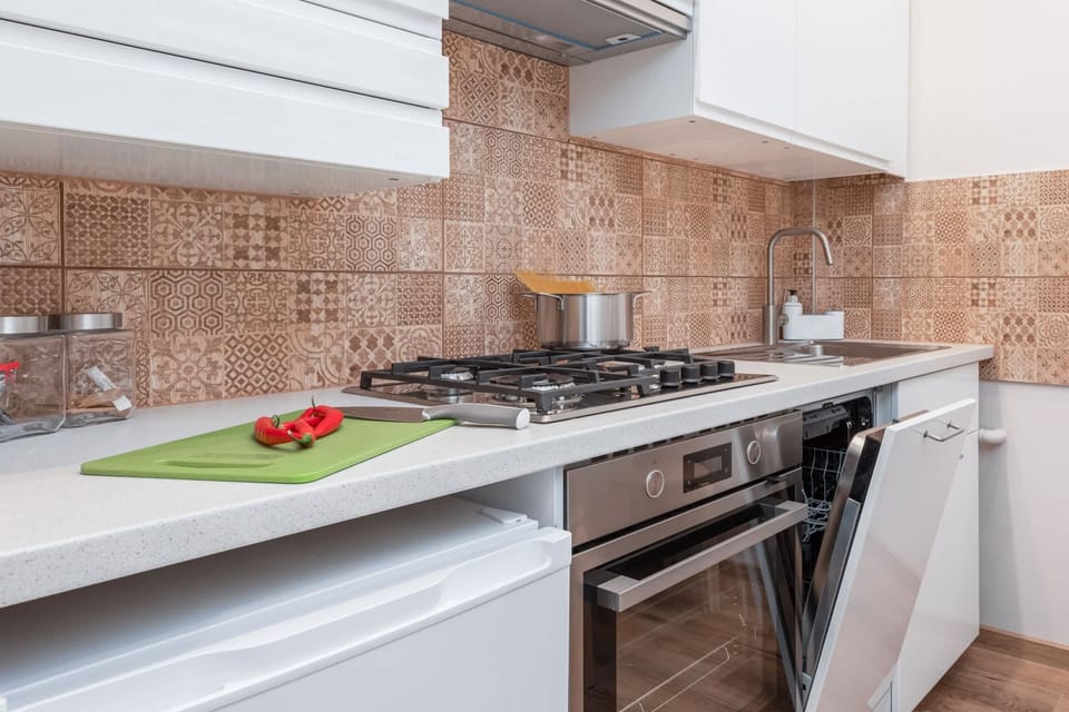 A close-up of the kitchen workspace with a cutting board and fresh vegetables, showcasing functionality.
