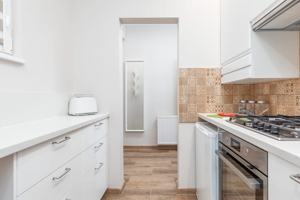 A modern kitchen layout featuring a gas stove, tiled backsplash, and ample counter space.
