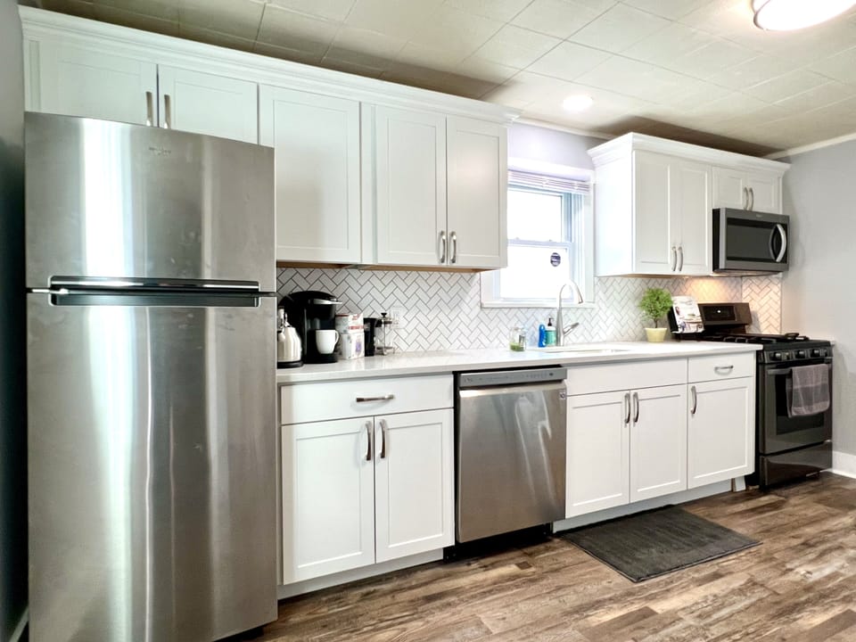 Newly updated kitchen with stainless appliances  and white quartz countertops. 