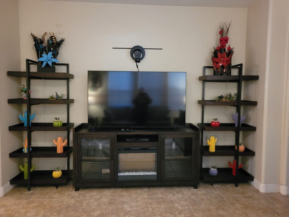 Entertainment center with large TV and a fireplace.