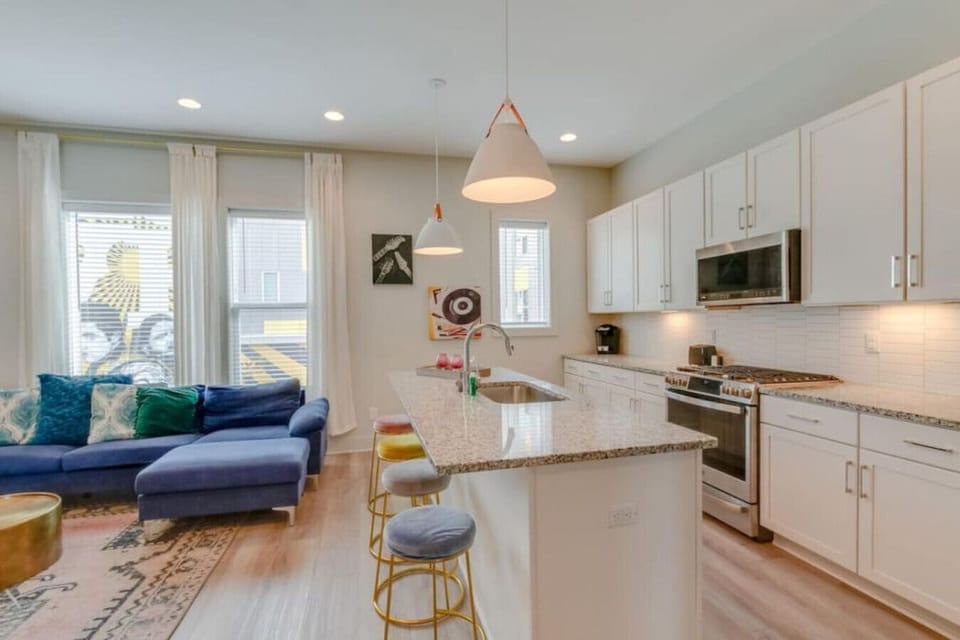 A modern kitchen with marble island and stainless steel appliances feels bright and functional.