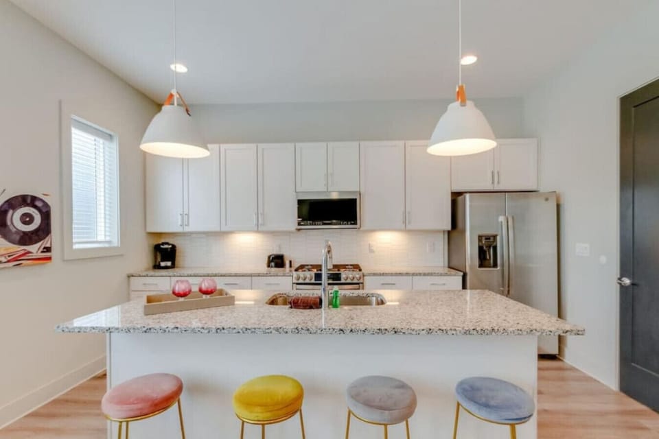 An open kitchen with island seating and a view into the living room shows the easy open-plan layout.