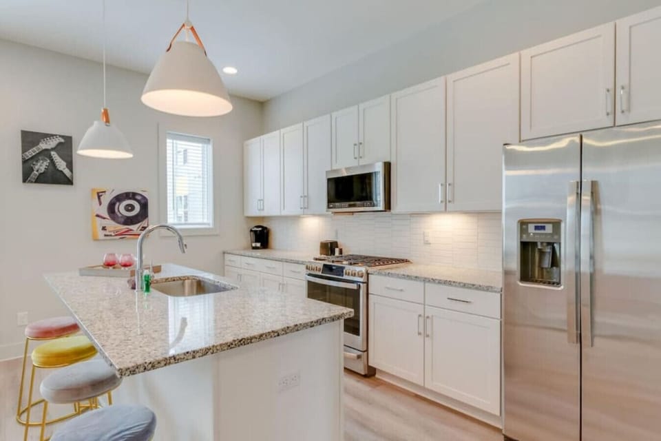 A modern kitchen with stainless steel appliances and a dining bar is ready for easy meals.