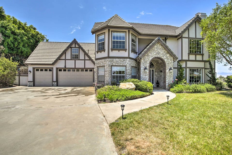 Front exterior with Tudor design, stone accents, arched entry, and driveway!