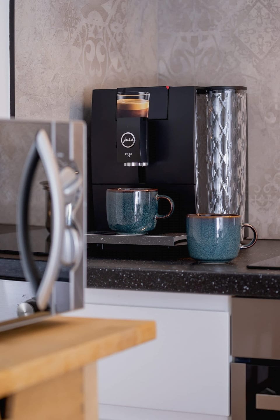 A coffee station with a coffee machine, mugs, and a cozy corner for refreshments.
